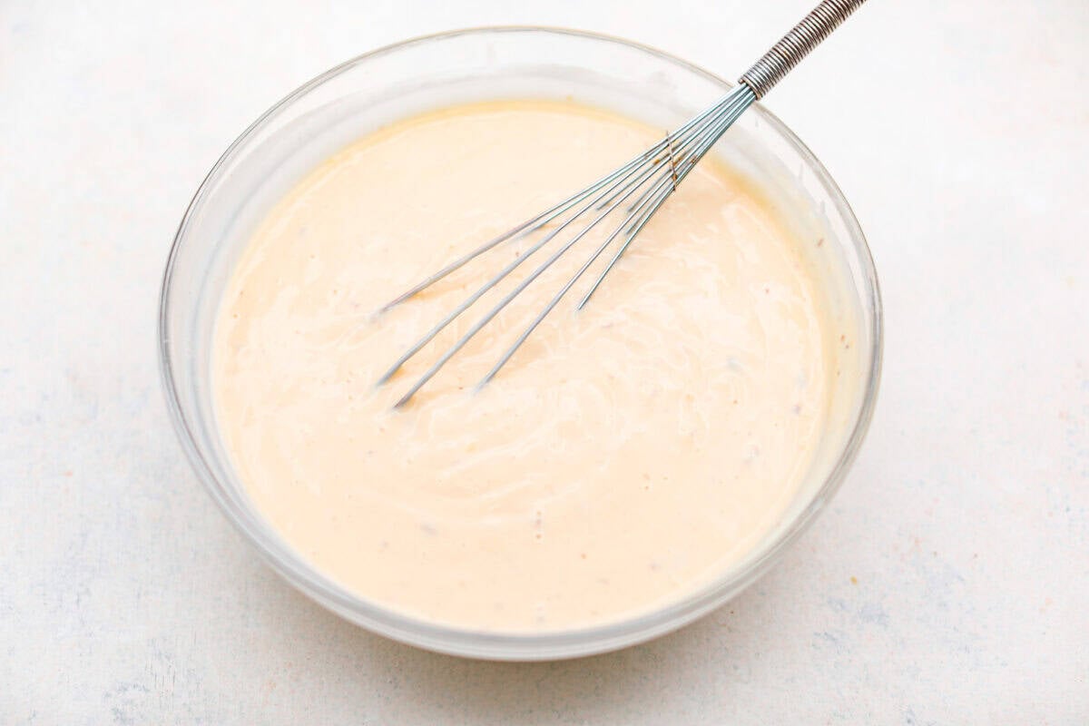 https://neuro-daily.report/beef-curry/ Overhead shot of evaporated milk and the cream of mushroom and chicken soups whisked together in a bowl.