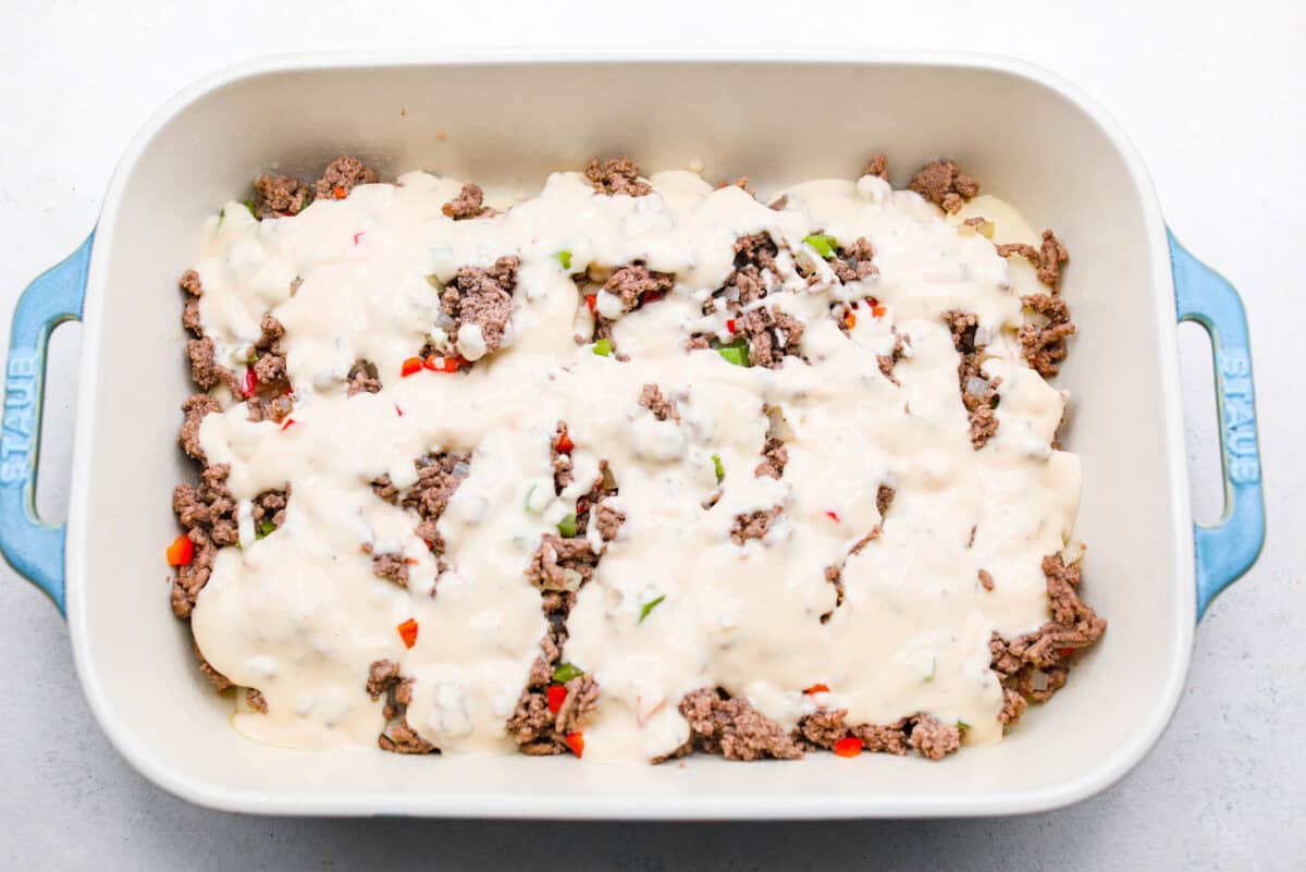 https://neuro-daily.report/beef-curry/ Overhead shot of the sauce spread over the beef and veggie mixture over the potatoes.