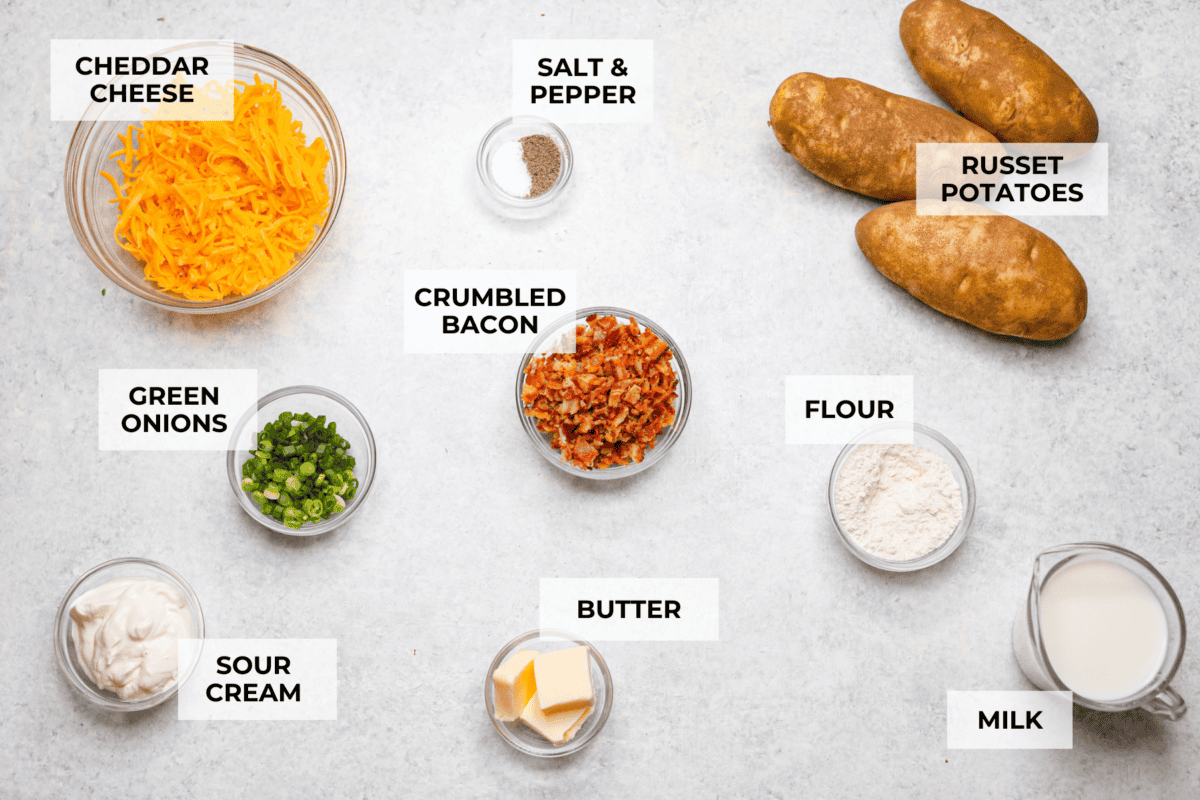 Loaded scalloped potatoes are rich, creamy, and "loaded" with flavor! This recipe combines tender potatoes baked to perfection in a velvety sauce topped with crispy bacon, green onions, and melty cheese. Overhead shot of labeled loaded scalloped potatoes ingredients.