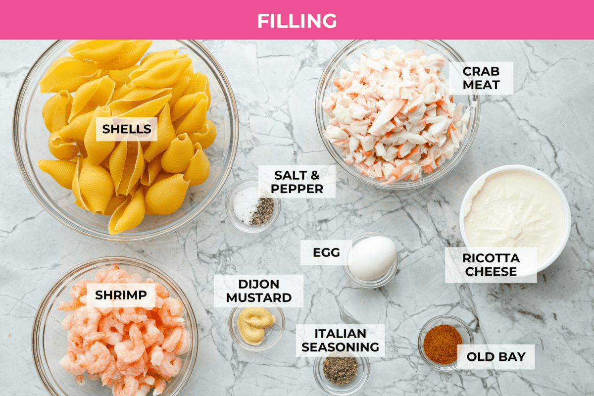 Seafood Stuffed Shells is a comforting meal that's sure to impress! Jumbo pasta shells are generously filled with a creamy, savory seafood filling and coated in a rich Alfredo-based sauce. Finish with a crispy crumb topping for an irresistible dinner! Overhead shot of labeled seasfood stuffed shells filling ingredients.