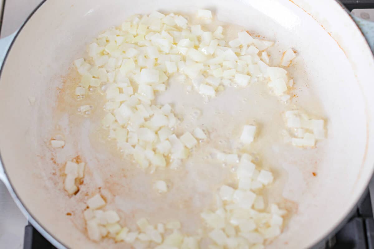 Mushroom orzo is a tasty, comforting side dish! It combines tender orzo pasta with rich, earthy mushrooms in a creamy sauce. It’s easy to make and sure to impress with satisfying texture and savory flavors. Overhead shot of onions cooking in a skillet.