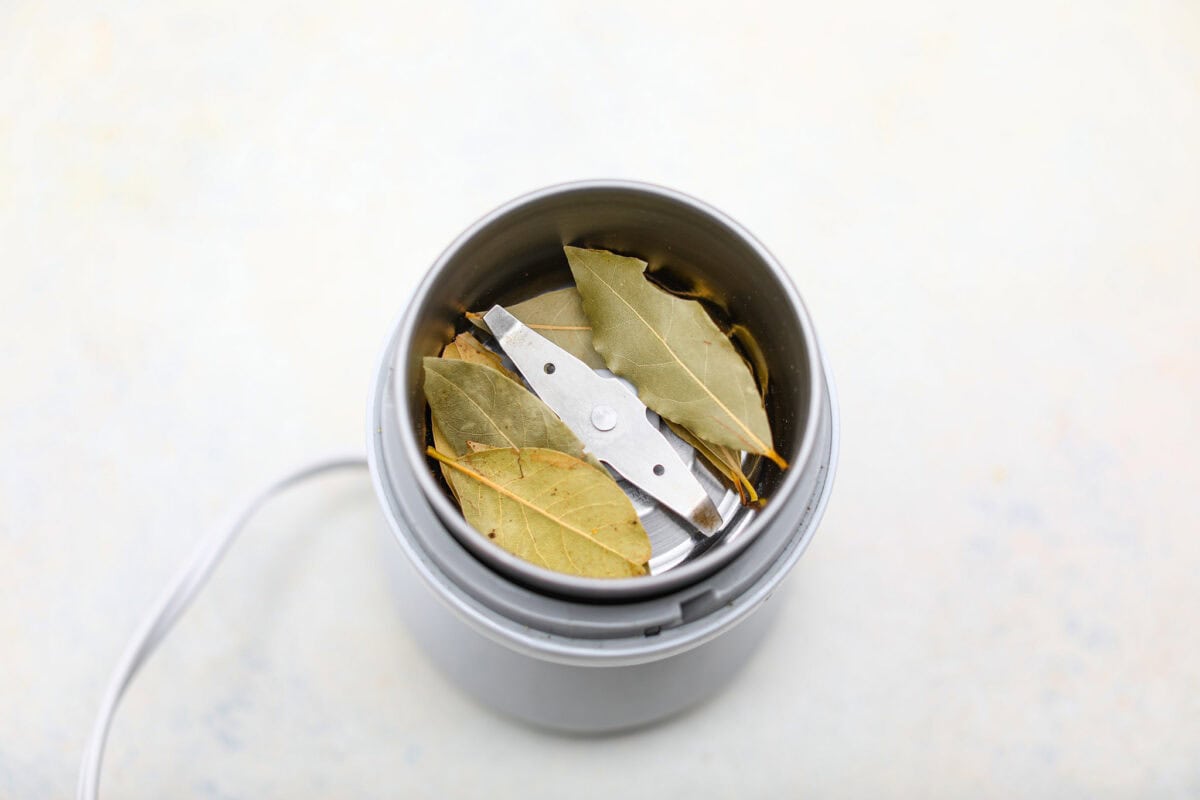 https://www.target.com/p/bodum-bistro-blade-grinder-stainless-steel/-/A-54612773#lnk=sametab Overhead shot of bay leaves in a spice or coffee grinder.