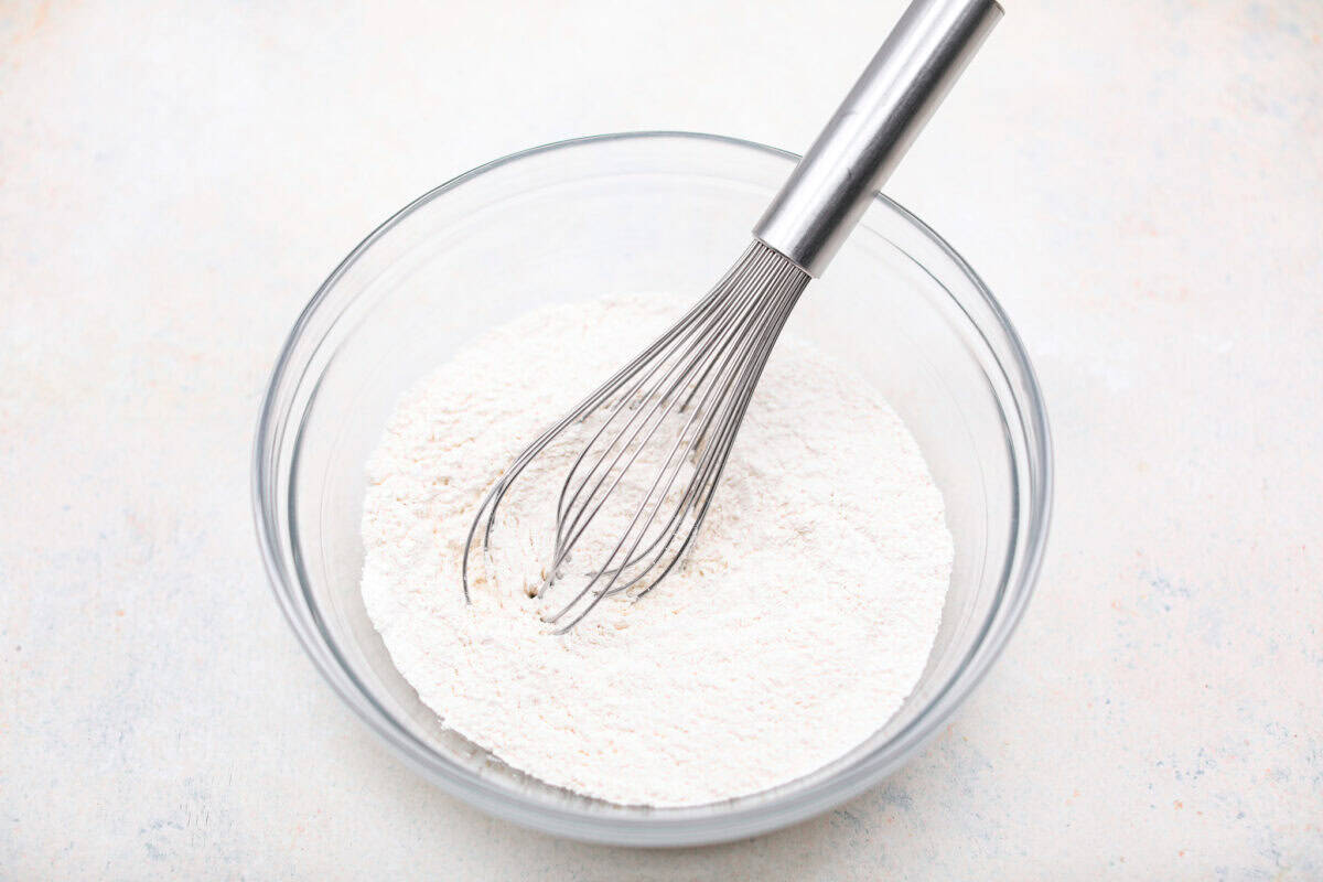 This creamy Ricotta Pie has a milky cinnamon flavor with a hint of lemon. The flavor is incredible, and it's surprisingly light for a cheese-based custard with its buttery shortbread crust. Overhead shot of the dry ingredients whisked together in a bowl.