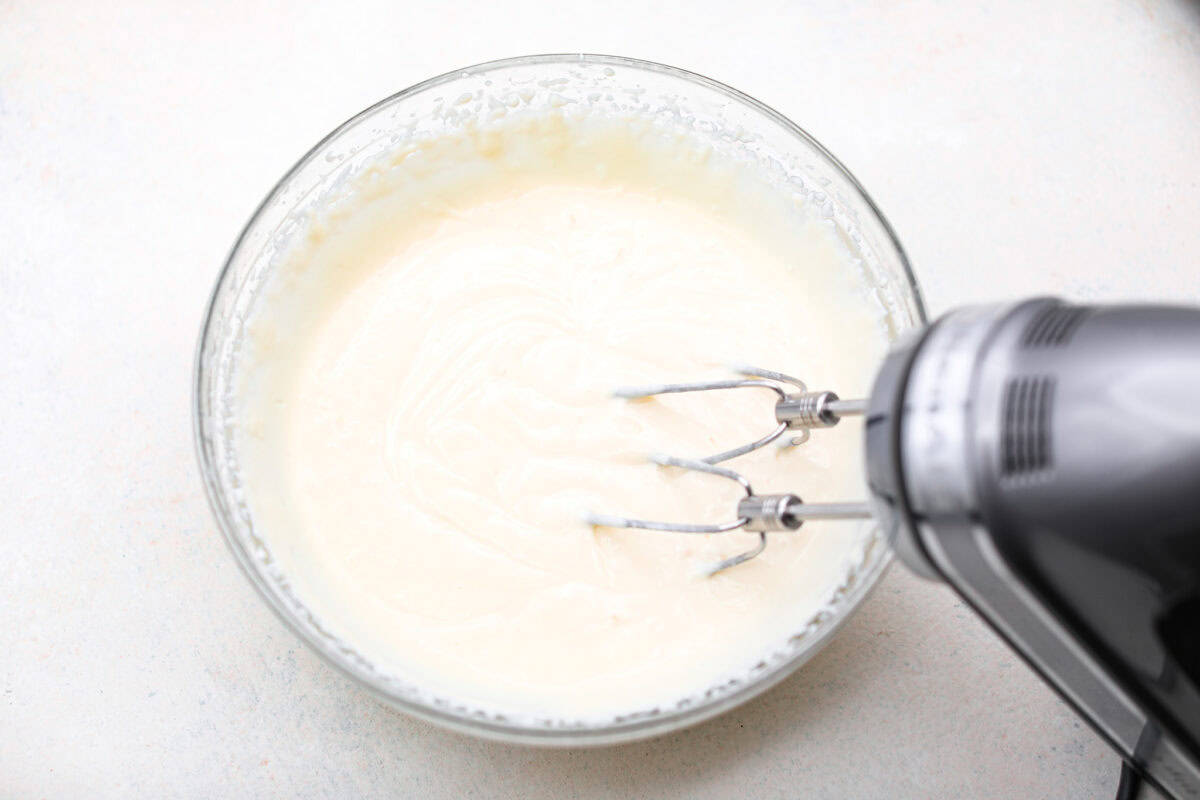 This creamy Ricotta Pie has a milky cinnamon flavor with a hint of lemon. The flavor is incredible, and it's surprisingly light for a cheese-based custard with its buttery shortbread crust. Overhead shot of the ricotta cheese being blended together with a hand mixer.