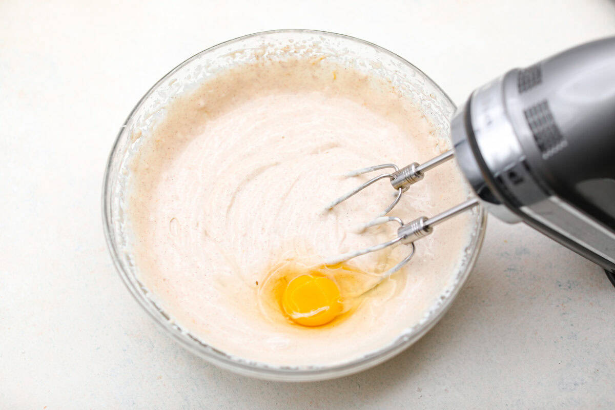 This creamy Ricotta Pie has a milky cinnamon flavor with a hint of lemon. The flavor is incredible, and it's surprisingly light for a cheese-based custard with its buttery shortbread crust. Overhead shot of the ricotta and other ingredients mixed together with an egg on top.