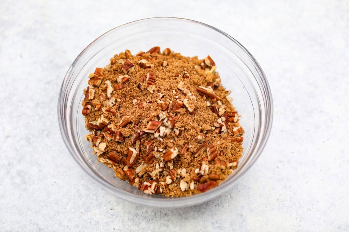 This Sock It to Me Cake is a moist, buttery Southern bundt cake with a delicious cinnamon-sugar pecan layer swirled through the middle. It became popular because of Duncan Hines in the 1960s and 1970s, and you'll understand why once you try it! Overhead shot of cinnamon, brown sugar and pecans mixed in a bowl.