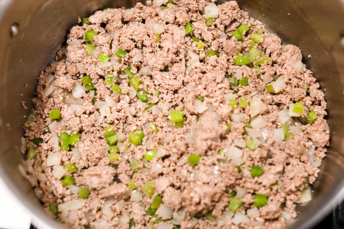 Turkey chili is such a comforting, satisfying meal! Packed with ground turkey, tender vegetables, hearty beans and a blend of bold spices, itโs filled with the most delicious flavor. Great for making ahead and feeding a crowd! Overhead shot of ground turkey added to the veggies in the pot.