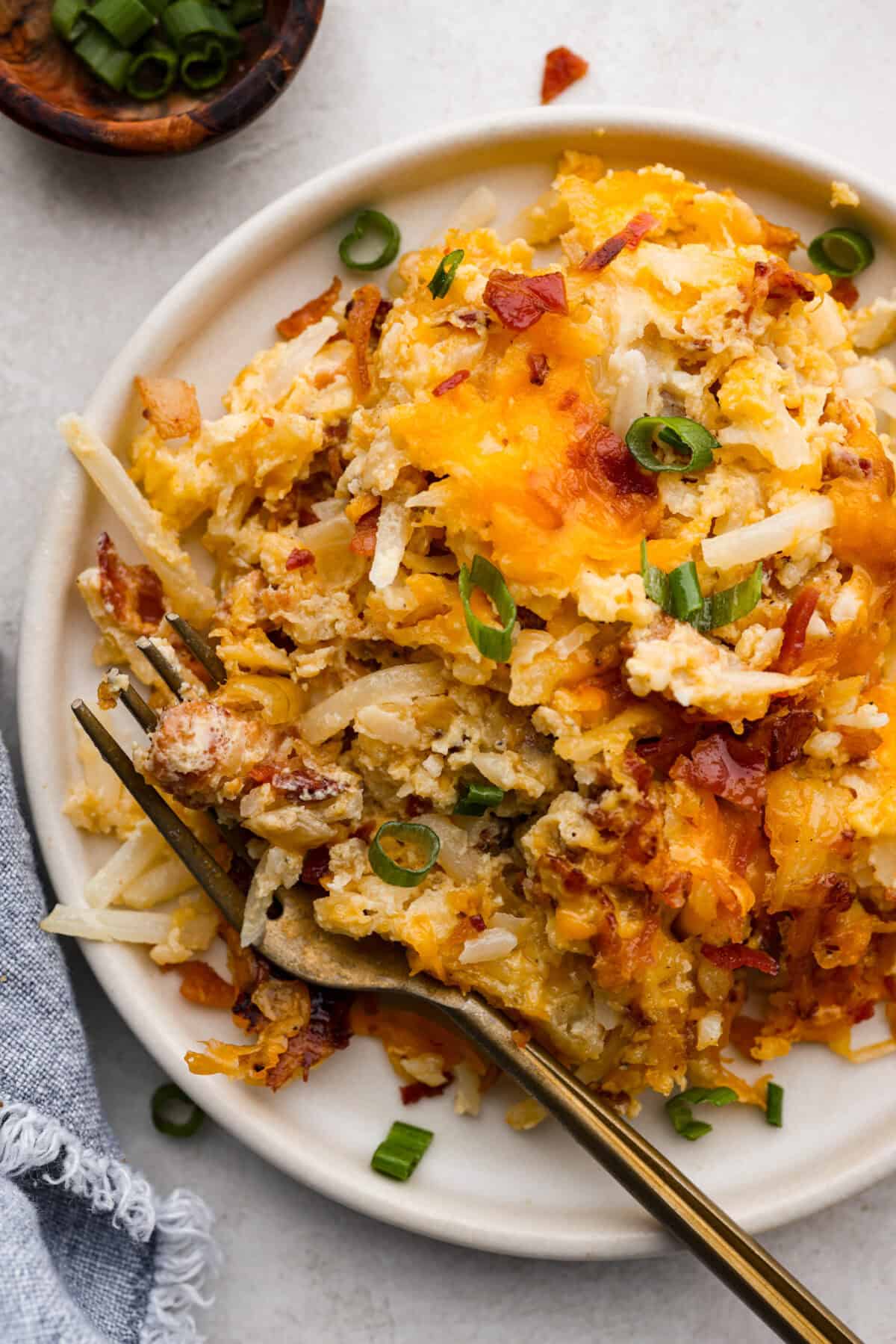 Kickstart your day with this hearty Amish Breakfast Casserole! It's loaded with crispy bacon, tender hash browns, and gooey melted cheese. This dish is a crowd-pleaser thatโs perfect for family breakfasts and holiday mornings! Overhead shot of plated amish breakfast casserole.