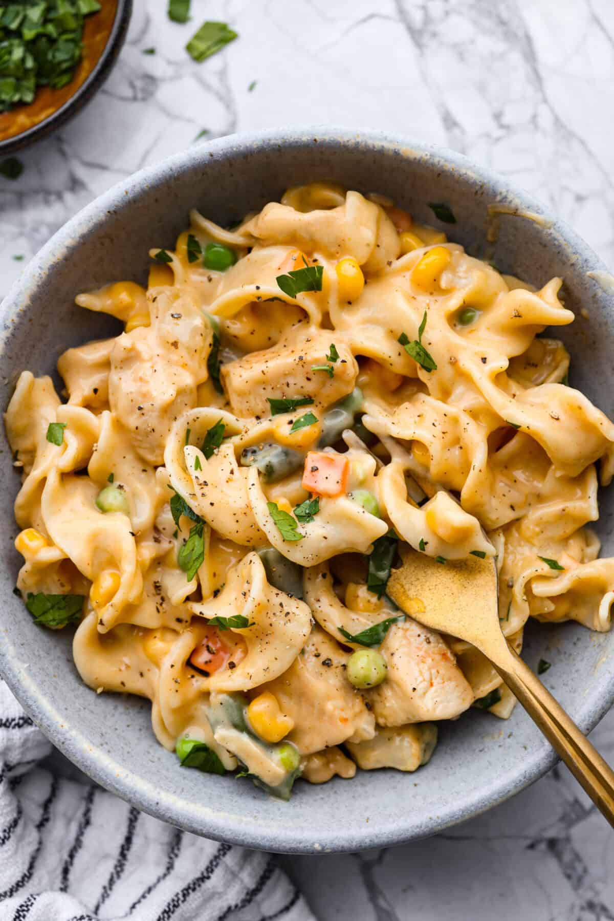 Chicken Pot Pie Pasta is a quick and easy twist on the classic comfort food. This one-pan recipe includes all the creamy, hearty flavors of a traditional chicken pot pie but swaps the pie crust for tender noodles. Itโs a simple, fuss-free meal ready in just 30 minutes! Overhead shot of plated chicken pot pie pasta.
