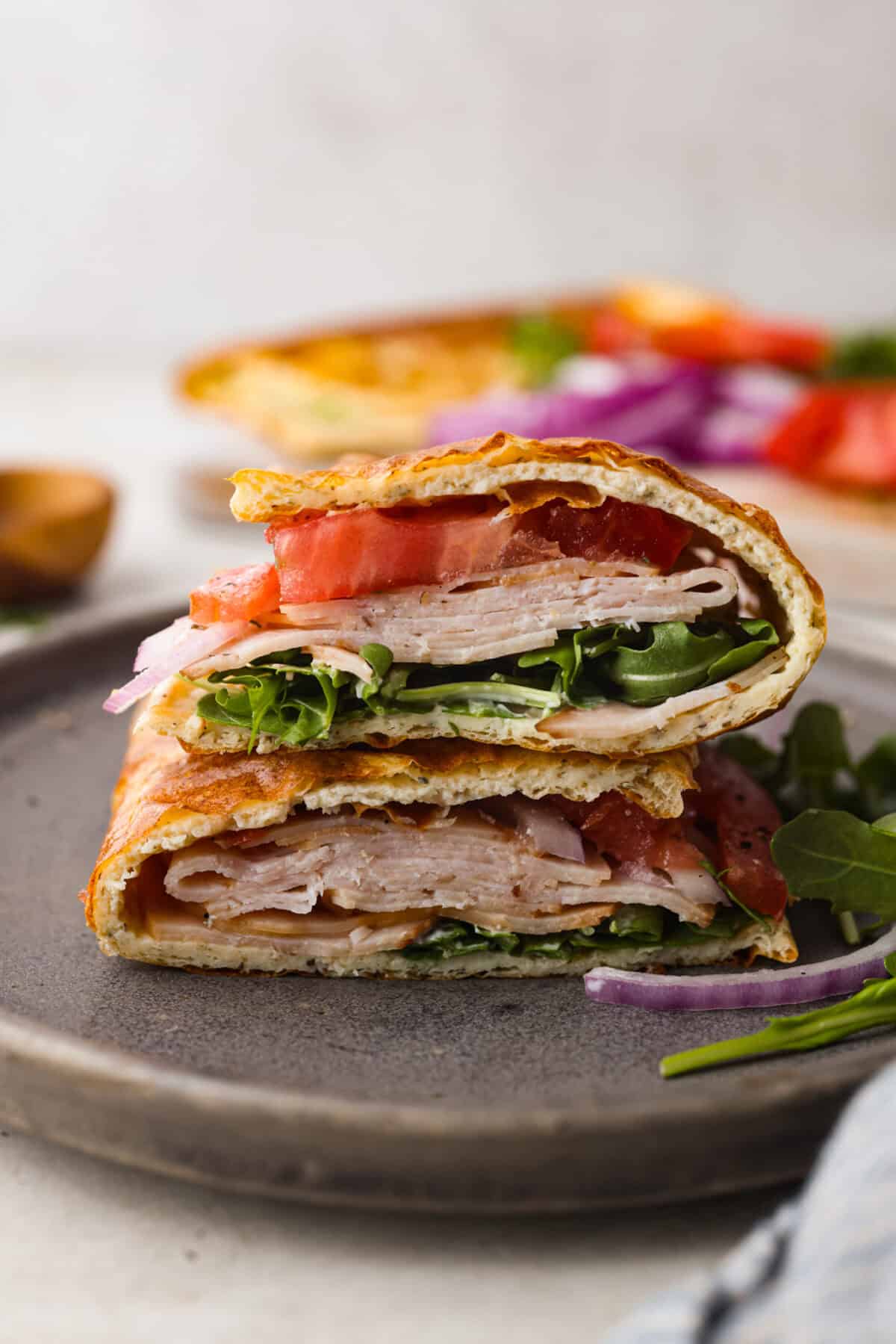 The viralย cottage cheese flatbreadย is a must try! Made with just cottage cheese, eggs and seasonings, itโs packed with almost 20 grams of protein. Use it to make delicious sandwiches or wraps for an easy lunch! Side shot of a sandwich made with cottage cheese flatbread cut in half and stacked.