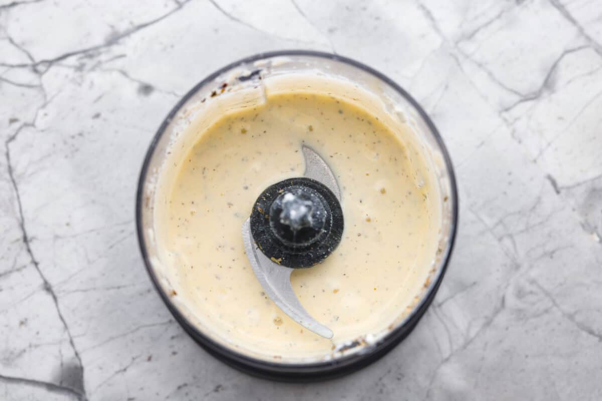 The viralย cottage cheese flatbreadย is a must try! Made with just cottage cheese, eggs and seasonings, itโs packed with almost 20 grams of protein. Use it to make delicious sandwiches or wraps for an easy lunch! Overhead shot of the food processor with the ingredients blended together.