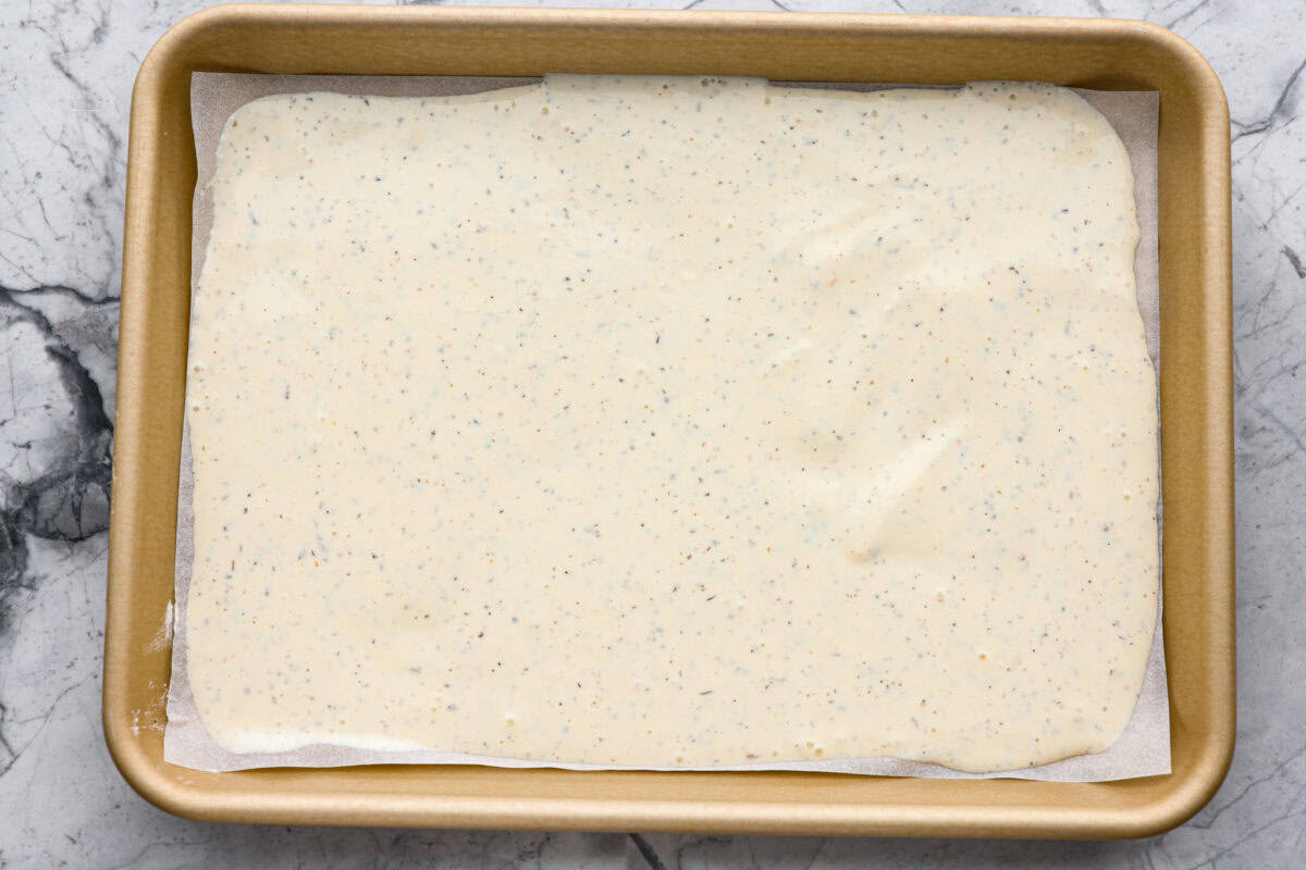 The viralย cottage cheese flatbreadย is a must try! Made with just cottage cheese, eggs and seasonings, itโs packed with almost 20 grams of protein. Use it to make delicious sandwiches or wraps for an easy lunch! Overhead shot of the whipped up ingredients spread out on a parchment paper in a cookie sheet.
