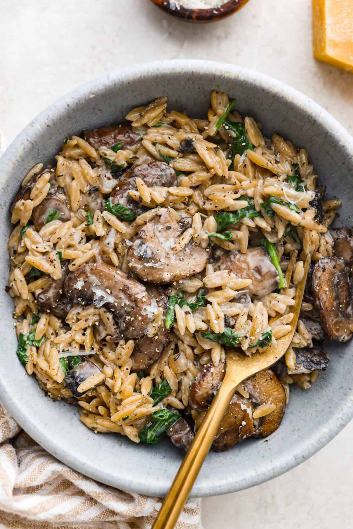 Mushroom orzo is a tasty, comforting side dish! It combines tender orzo pasta with rich, earthy mushrooms in a creamy sauce. It’s easy to make and sure to impress with satisfying texture and savory flavors. Overhead shot of plated mushroom orzo.