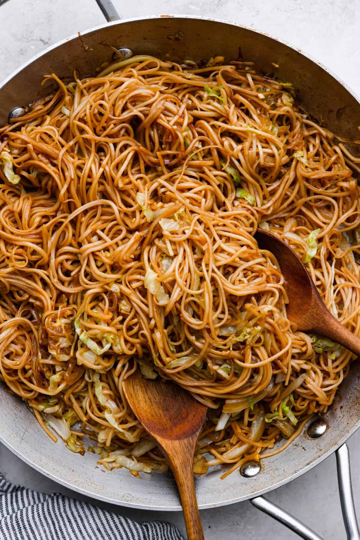 Add outbound links by finding items you can link through Target links. And add them the same way you would add an internal link by pasting the link into the bar. Overhead shot of Panda Express chow mein in a pan with two wooden serving spoons.