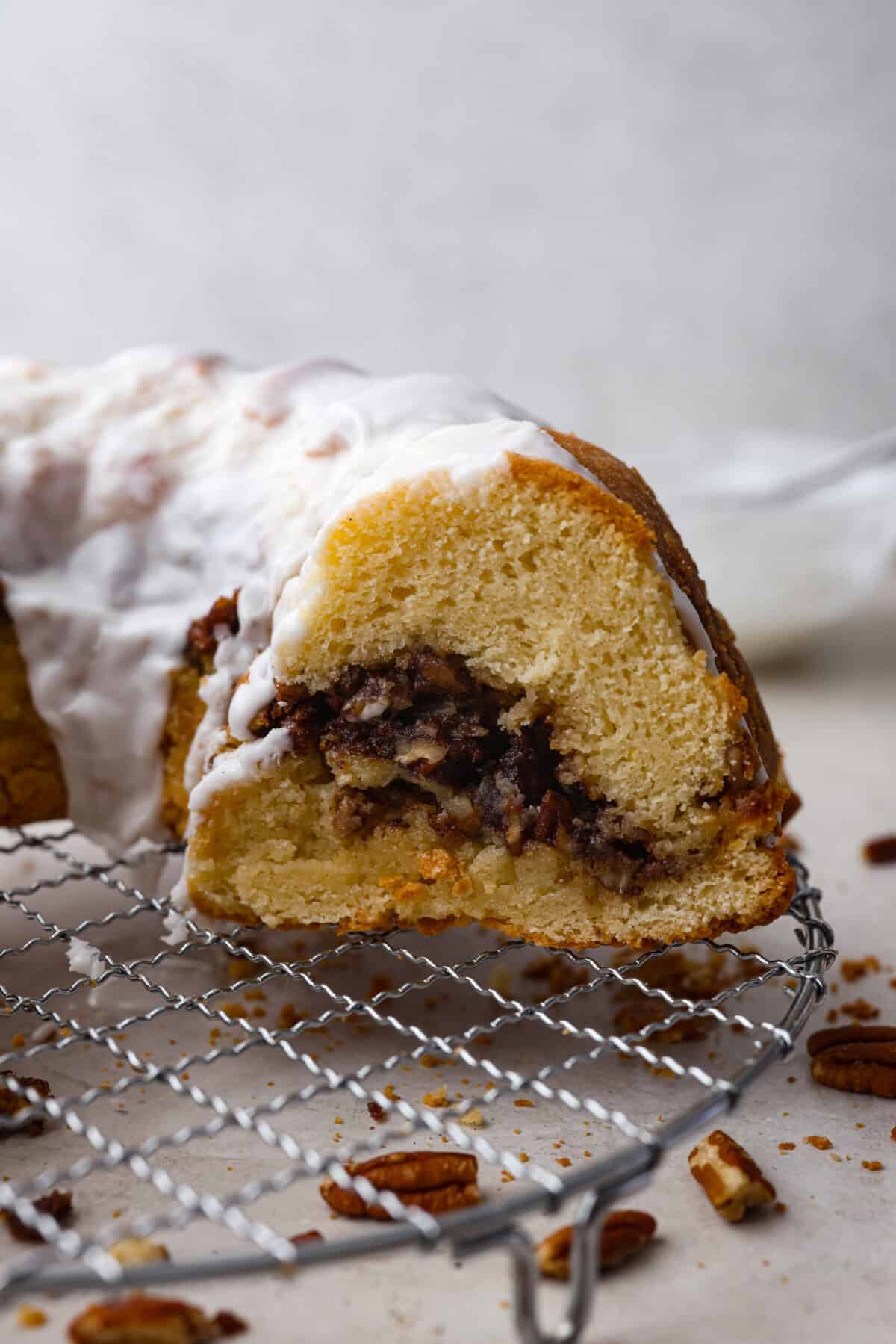 This Sock It to Me Cake is a moist, buttery Southern bundt cake with a delicious cinnamon-sugar pecan layer swirled through the middle. It became popular because of Duncan Hines in the 1960s and 1970s, and you'll understand why once you try it! Side shot of sock it to me cake on a cooling rack.
