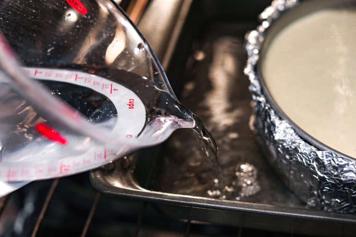 Creme Brulee Cheesecake is the perfect merging of two beloved desserts! It has the rich, creamy texture of cheesecake with the caramelized sugar topping of classic crรจme brรปlรฉe. This irresistible treat is the best of both worlds! Pouring water into a roasting pan.