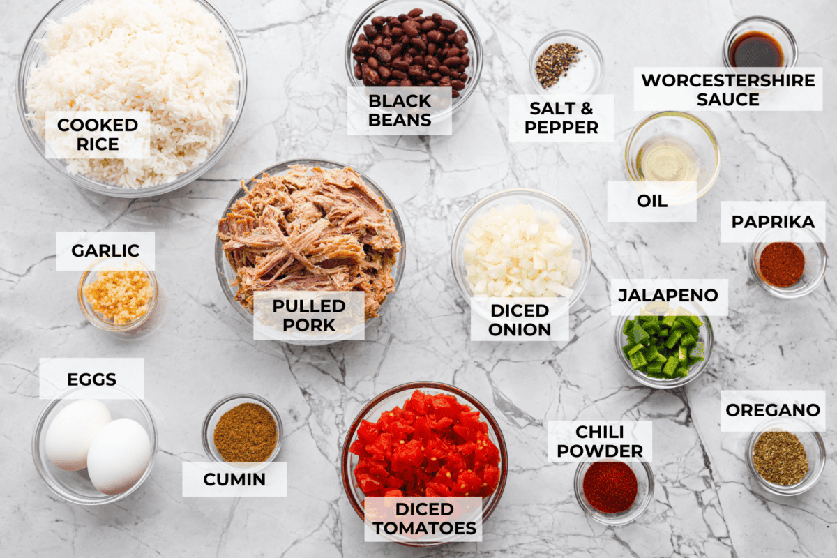Cowboy Fried Rice is a Tex-Mex twist on the classic! It's loaded with bold spices and hearty ingredients like pulled pork, black beans, and diced tomatoes. Made in one skillet and ready in just 30 minutes, itโs the perfect quick and satisfying meal for busy nights. Overhead shot of labeled ingredients.