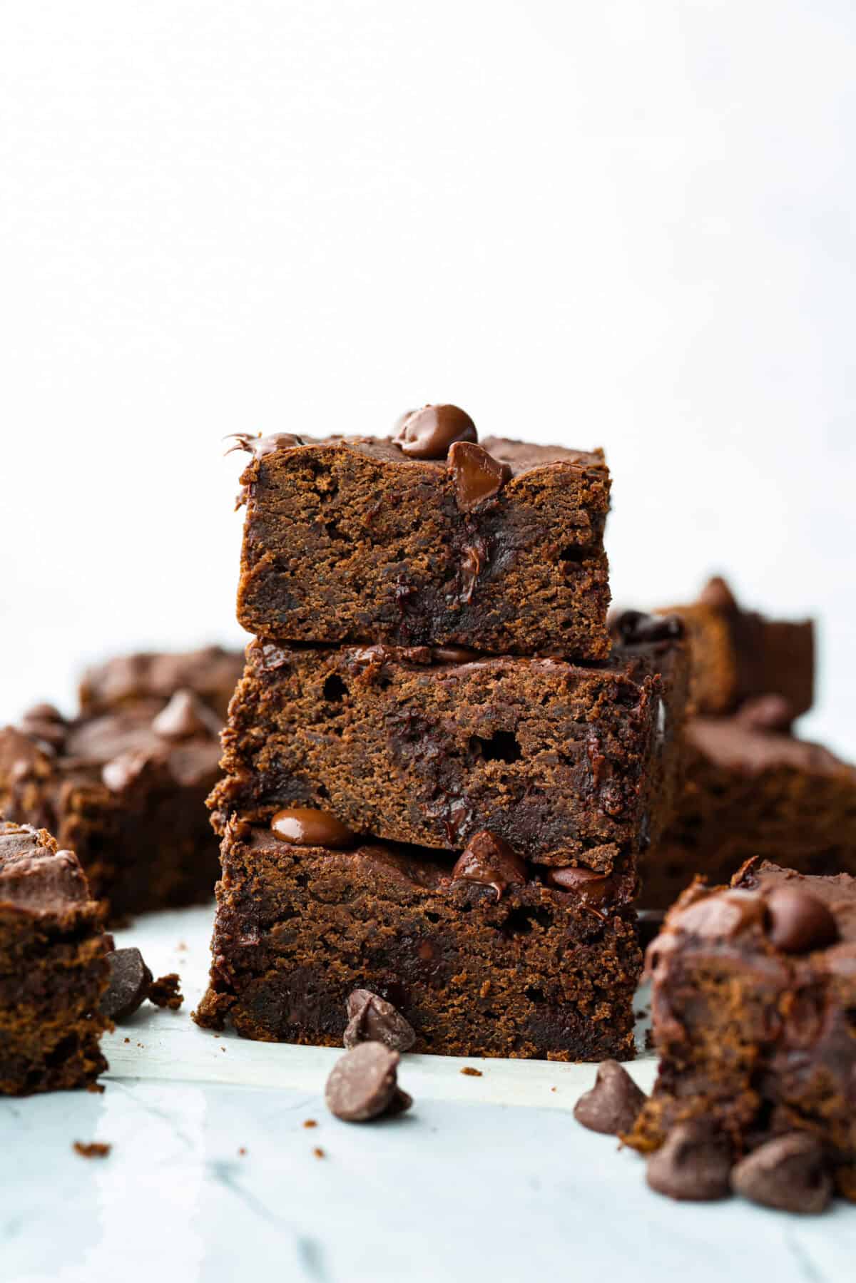 Black bean brownies are rich, fudgy, and packed with chocolatey goodness! They have a slightly denser texture, similar to a protein bar, but still satisfy that brownie craving. While adults may notice a slight difference from traditional brownies, kids wonโt be able to tell! Side shot of stacked black bean brownies.