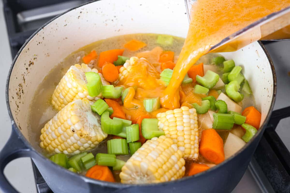 Caldo de Pollo is a comforting and flavorful Mexican chicken soup made with tender chicken, hearty vegetables, and a rich, savory broth. Itโs warm, nourishing, and perfect for cozying up on a chilly day! Angle shot of someone pouring blended ingredients back into the pot with other vegetables.