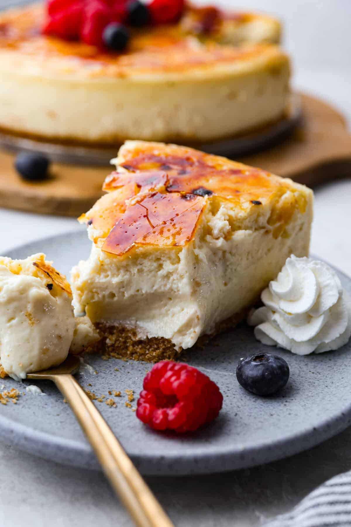Creme Brulee Cheesecake is the perfect merging of two beloved desserts! It has the rich, creamy texture of cheesecake with the caramelized sugar topping of classic crรจme brรปlรฉe. This irresistible treat is the best of both worlds! Close up shot of a slice of plated creme brรปlรฉe cheesecake.