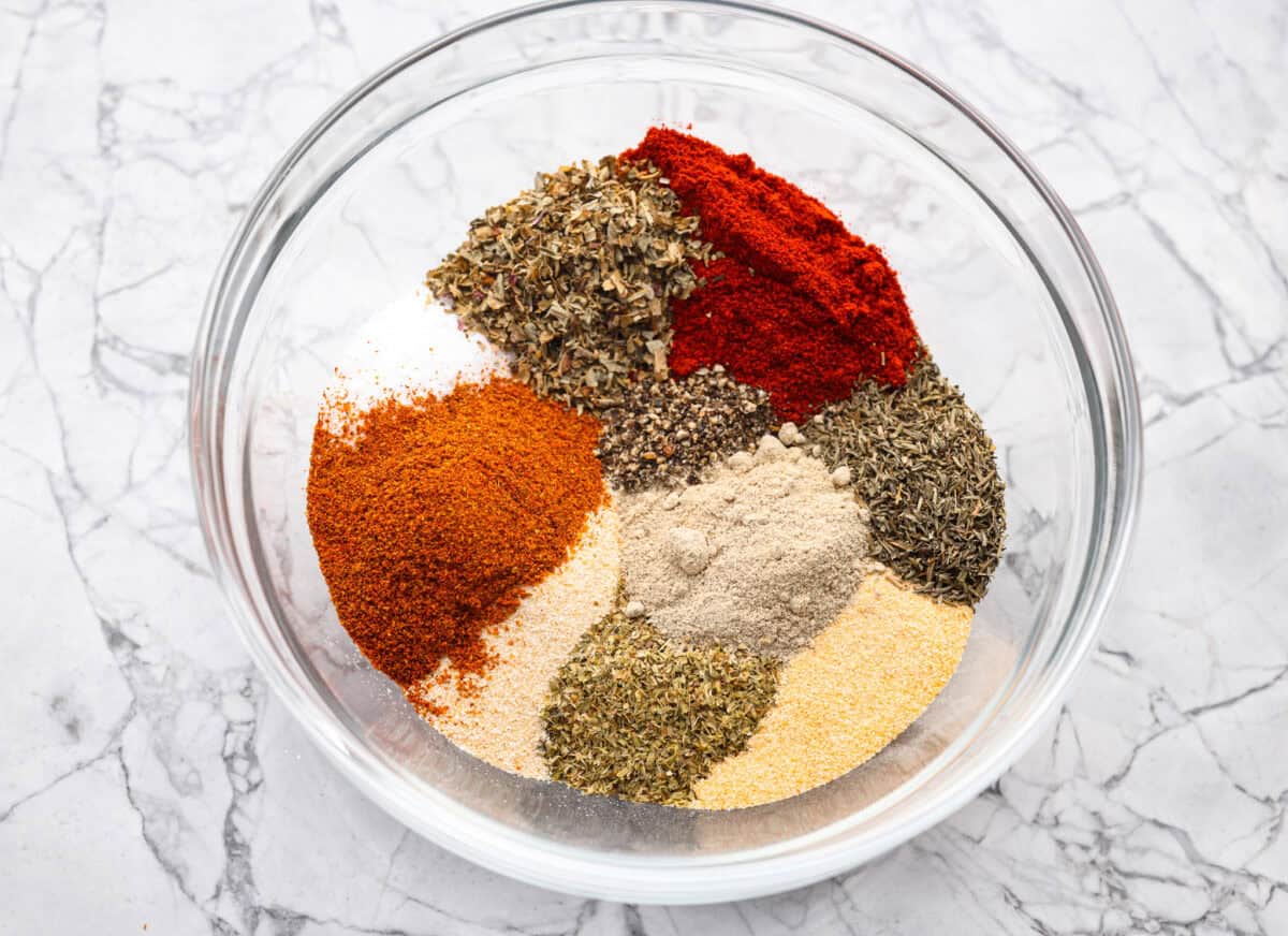 Creole seasoning is a bold and flavorful spice blend that brings the lively taste of Louisiana to your kitchen! It has the perfect balance of herbs, spices, and a touch of heat. It adds depth to everything from gumbo and jambalaya to roasted veggies and seafood. Overhead shot of the ingredients in a mixing bowl.