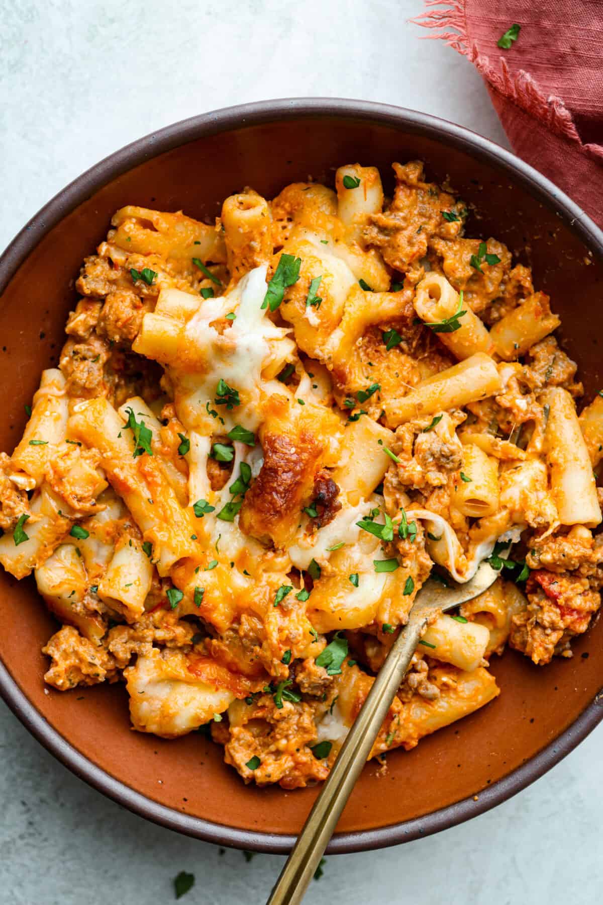 Million Dollar Baked Ziti is the ultimate comfort food that tastes like a million bucks! It's packed with layers of tender noodles, ground meat, spaghetti sauce, and plenty of cheesy goodness. There is something for the whole family in this hearty, crowd-pleasing dish! Overhead shot of plated million dollar baked ziti.