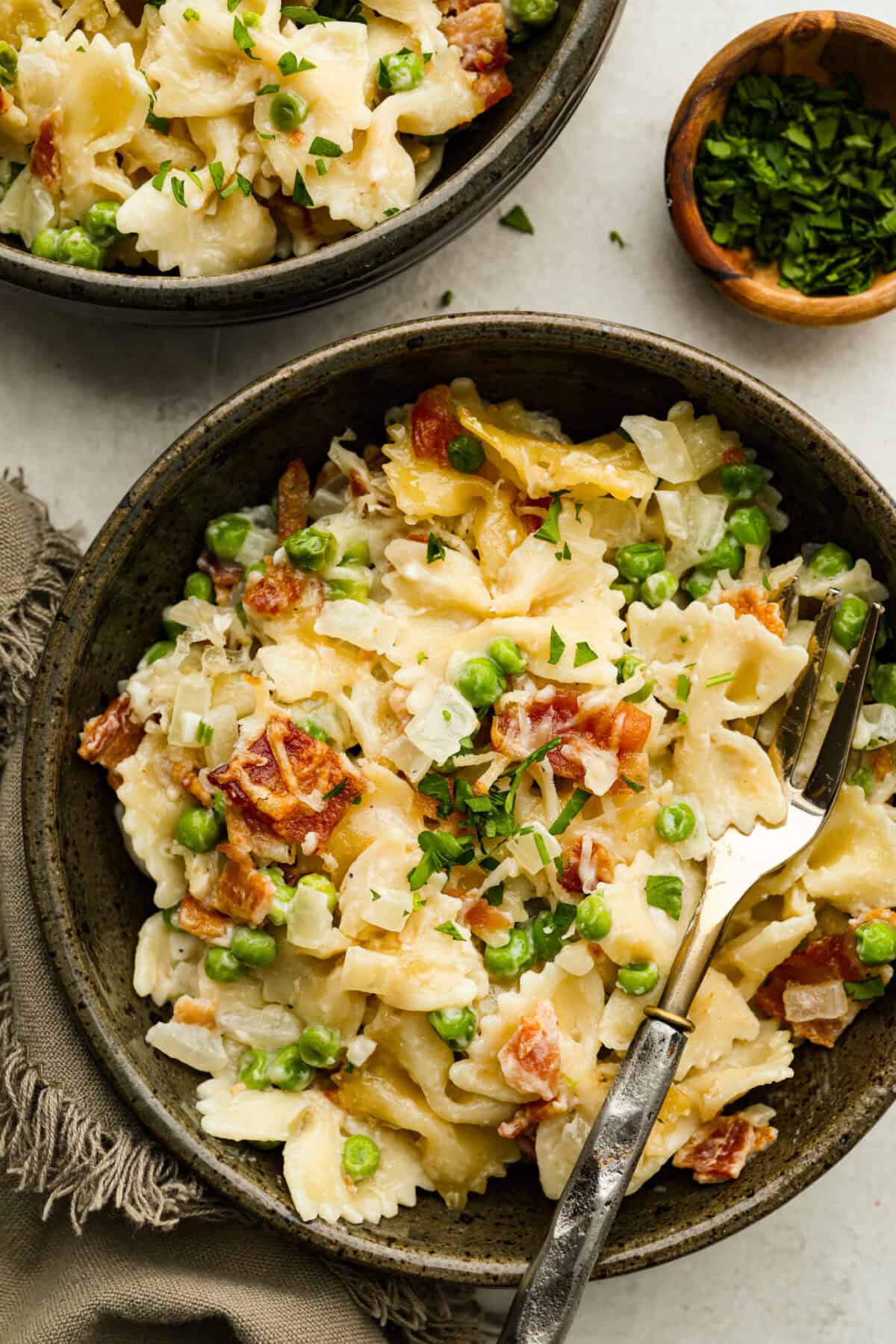 Stanley Tucci pasta casserole is everything you want in a casserole. It's simple to make and incredibly flavorful! TikTok is going crazy over the crispy bacon, tender peas, and the creamy, cheesy sauce that holds everything together! Overhead shot of plated Stanley Tucci pasta casserole.