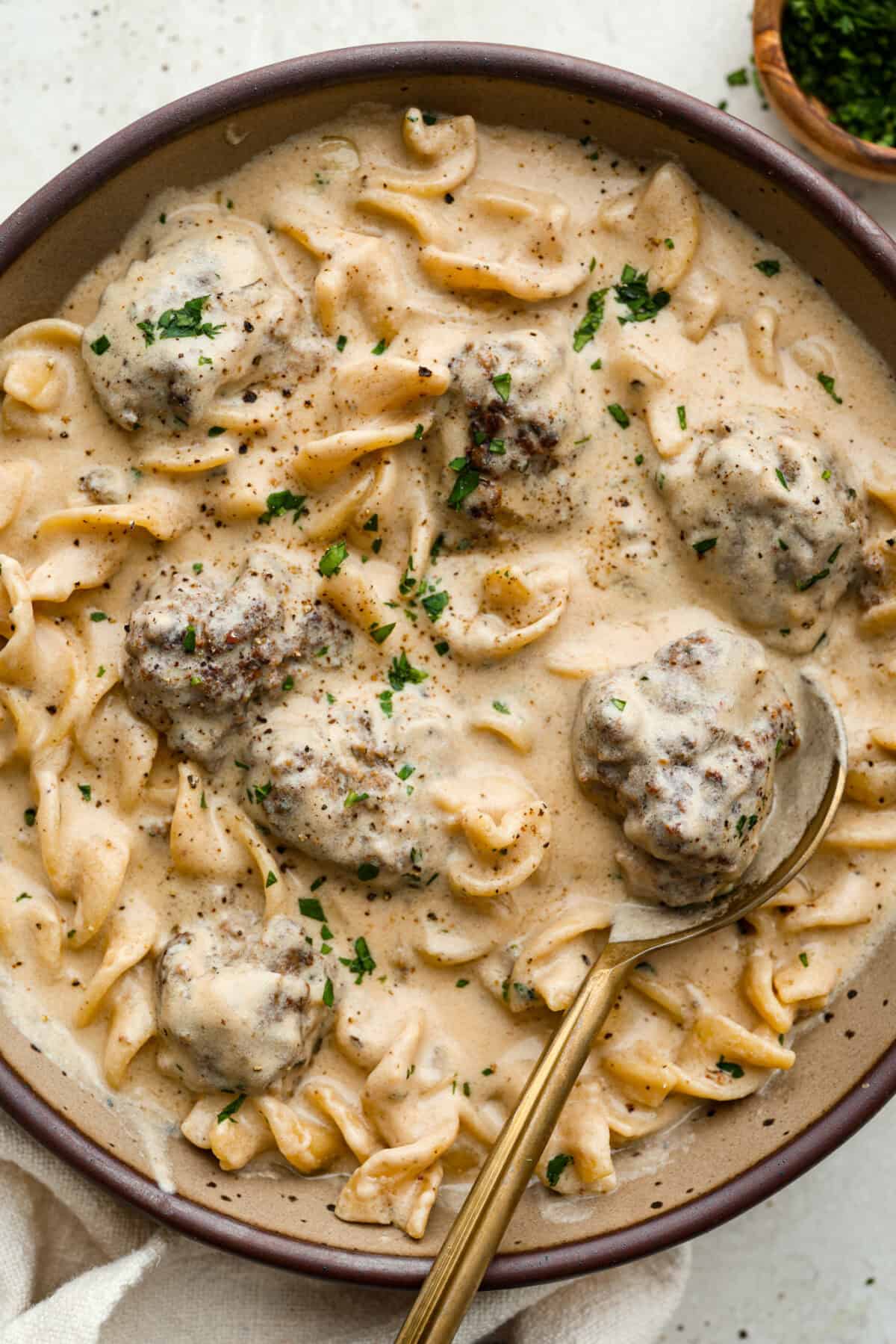 Warm and comforting, this cozy Swedish meatball soup is the perfect meal for chilly days. Juicy meatballs simmer in a rich, savory broth with tender noodles, making every spoonful satisfying. It’s easy to make and sure to become a family favorite! Overhead shot of plated Swedish meatball soup.