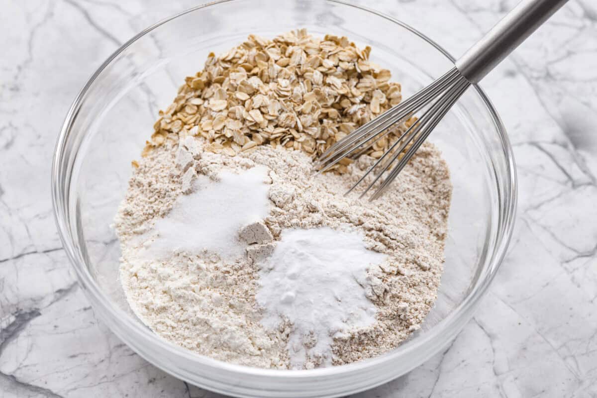 Irish Brown Bread is a delicious twist on classic soda bread, offering a slightly sweet, rich, and hearty flavor. It comes together quickly and makes a great breakfast, snack, or side with dinner. It's so yummy with honey, butter, or jam! Overhead shot of all of the dry ingredients in a bowl.