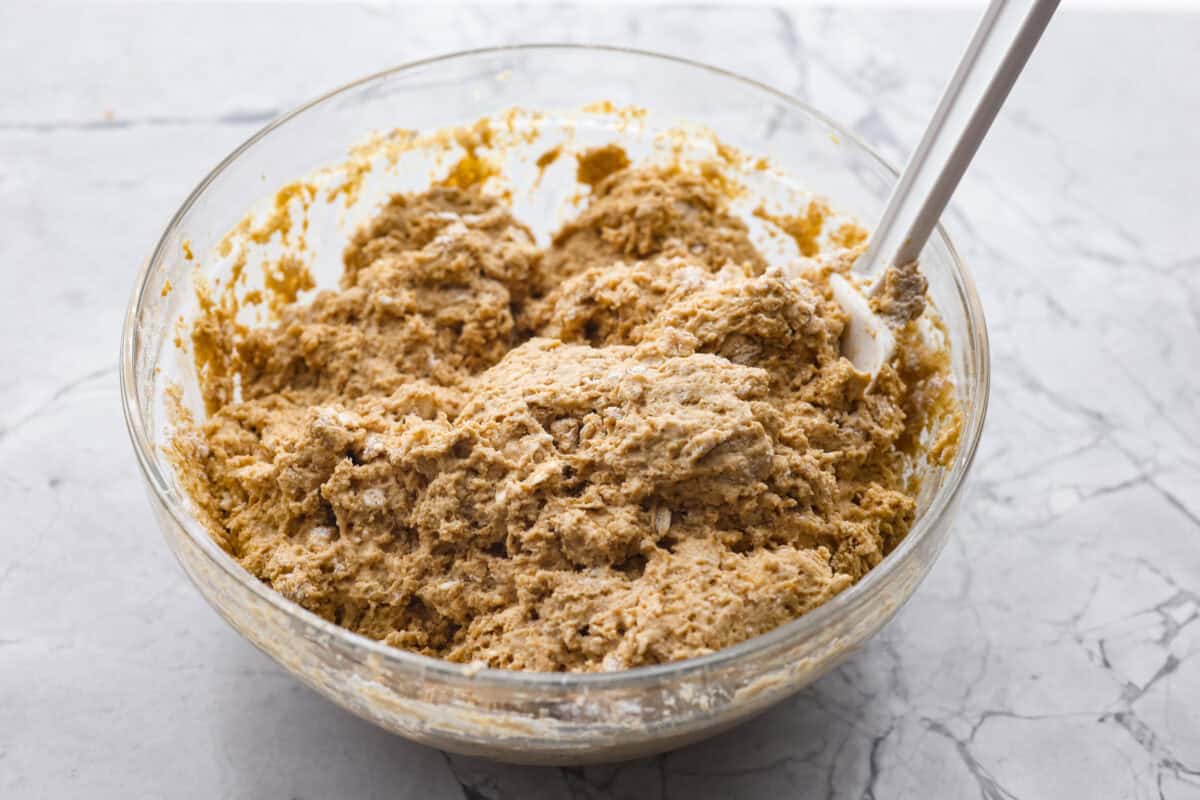 Irish Brown Bread is a delicious twist on classic soda bread, offering a slightly sweet, rich, and hearty flavor. It comes together quickly and makes a great breakfast, snack, or side with dinner. It's so yummy with honey, butter, or jam! Angle shot of both the dry and wet ingredients mixed together in a bowl.