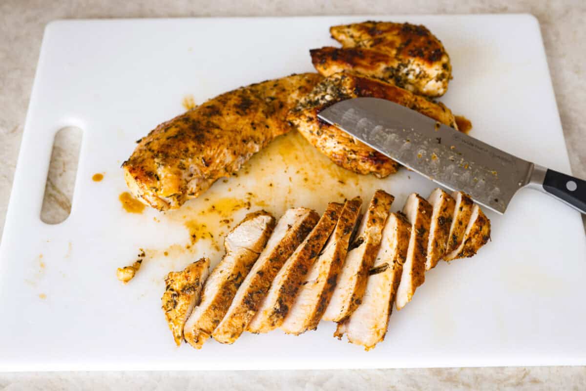 Marry Me Chicken Ramen is the ultimate comfort food mashup you didn’t know you needed! Searing the chicken first locks in moisture and flavor, then it simmers with fresh basil and tangy sun-dried tomatoes in a rich, velvety broth. Overhead shot of cooked chicken sliced on a cutting board.