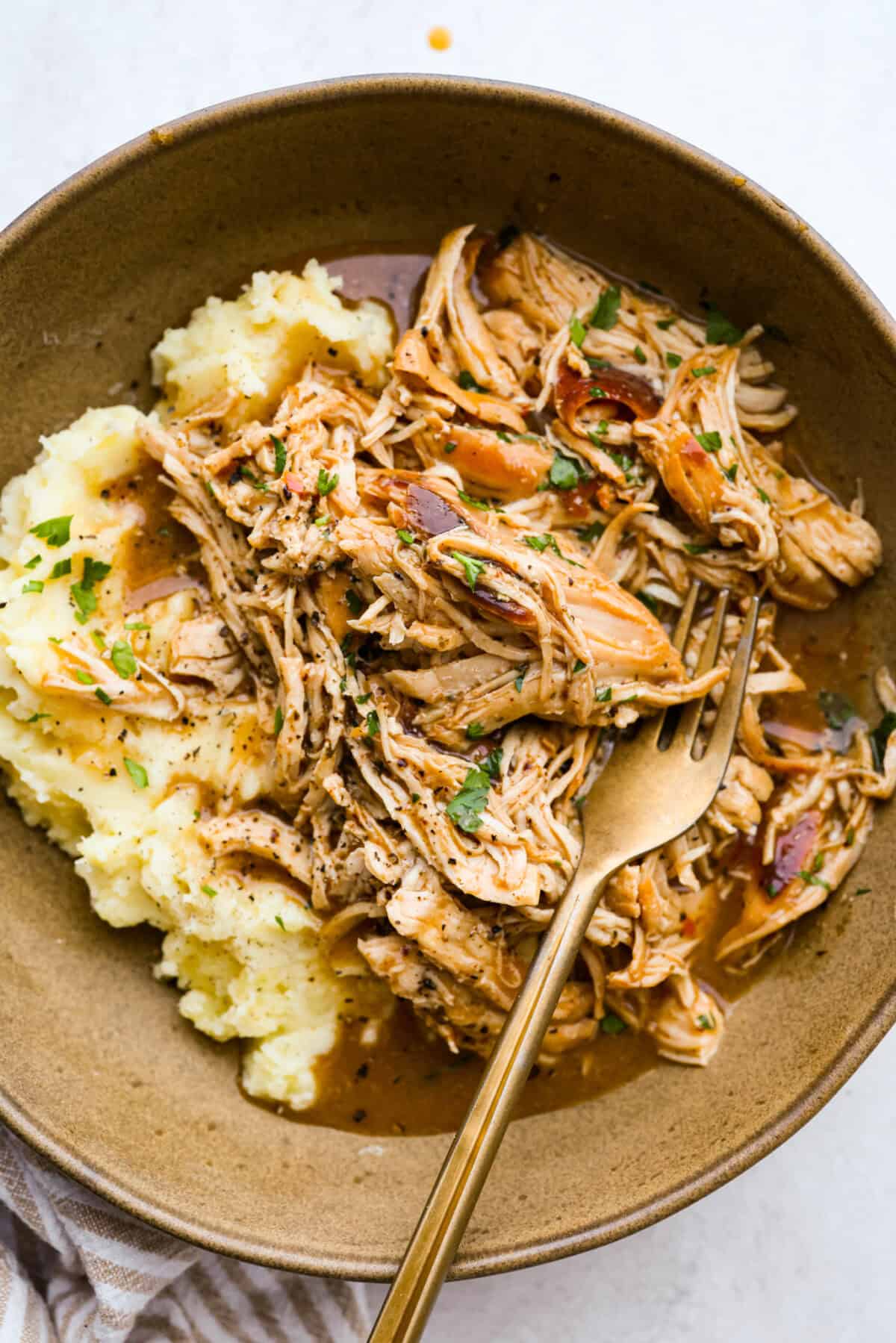 You guys can't get enough of my 3 packet roast, so it's time for a new version, 3 Packet Crockpot Chicken! It takes just 5 minutes to prep and comes out juicy, tender, and full of flavor. 3 packet crockpot chicken on a plate with mashed potatoes.