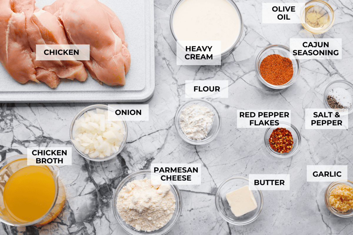 Creamy Cajun Chicken is the perfect combination of bold, zesty flavors and rich, velvety sauce. Juicy, tender chicken is coated in a perfectly spiced Cajun seasoning and simmered in a luscious, creamy sauce thatโs packed with flavor. Overhead shot of labeled ingredients.