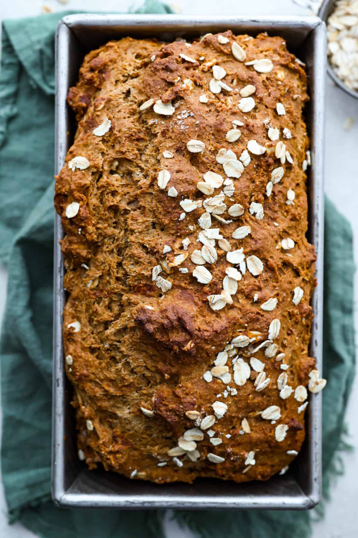 Irish Brown Bread is a delicious twist on classic soda bread, offering a slightly sweet, rich, and hearty flavor. It comes together quickly and makes a great breakfast, snack, or side with dinner. It's so yummy with honey, butter, or jam! Overhead shot of freshly baked Irish brown bread cooling in a loaf pan.