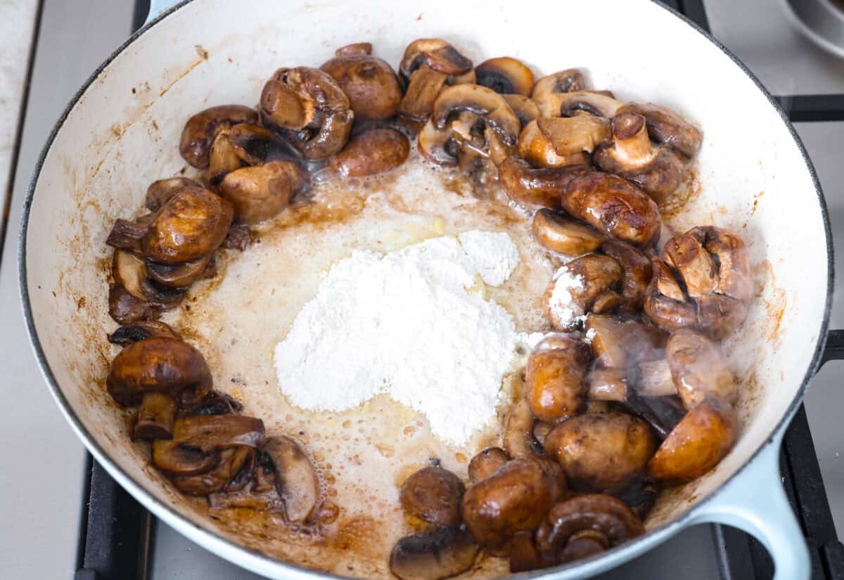 The key to making these Marry Me Mushrooms irresistibly flavorful is getting the perfect sear on the mushrooms. This locks in their natural flavors and texture. Then they simmer in a creamy garlic parmesan sauce with robust sun-dried tomatoes and herbs. It’s a simple technique that makes all the difference! Overhead shot of cooked mushrooms, butter and flour in a skillet.