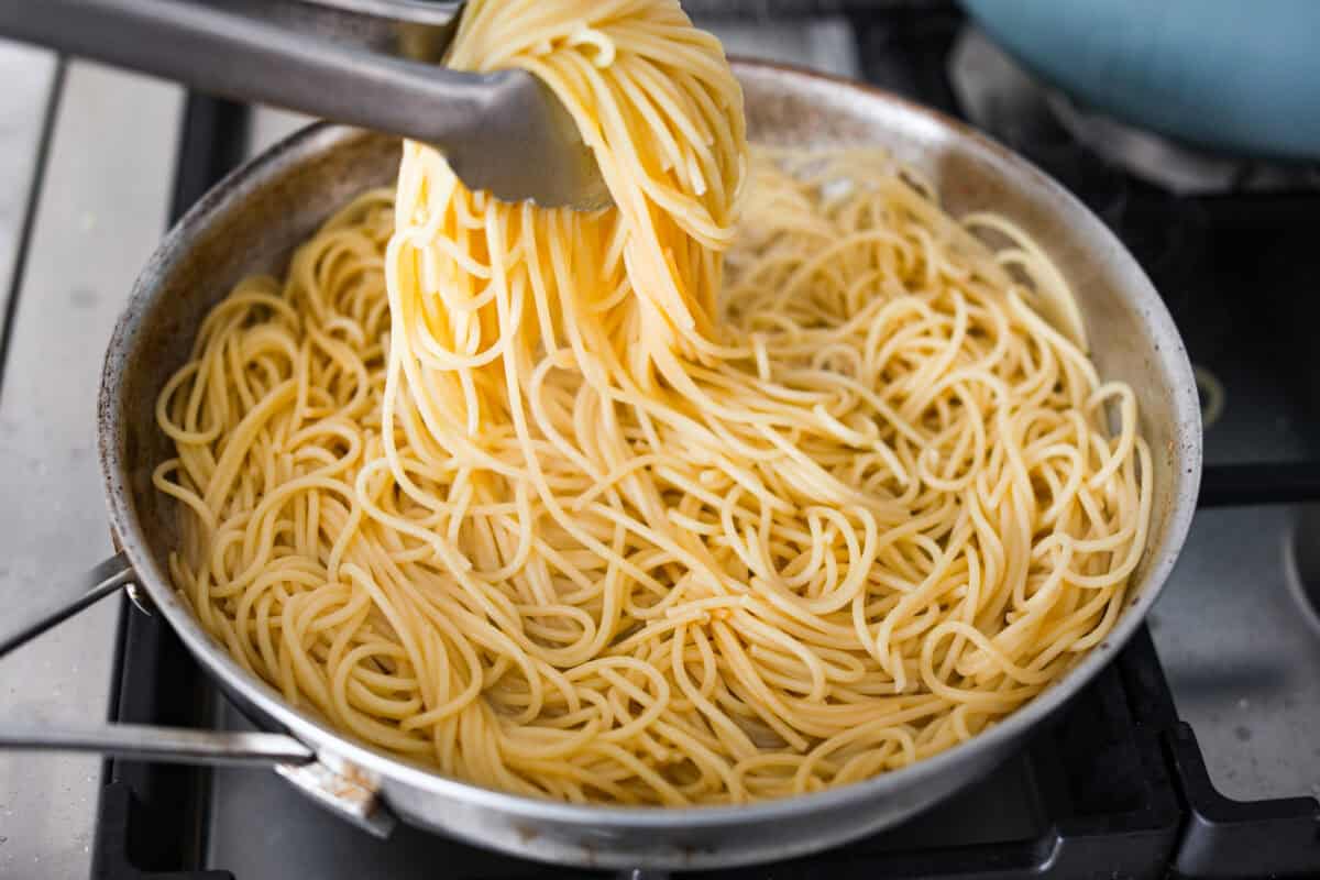 You guys! My pasta carbonara is the real deal—creamy, dreamy, and so full of flavor! Just eggs, cheese, pancetta, and pasta magic. It feels restaurant worthy but takes less than 30 minutes! Someone tossing the noodles in the rendered fat.