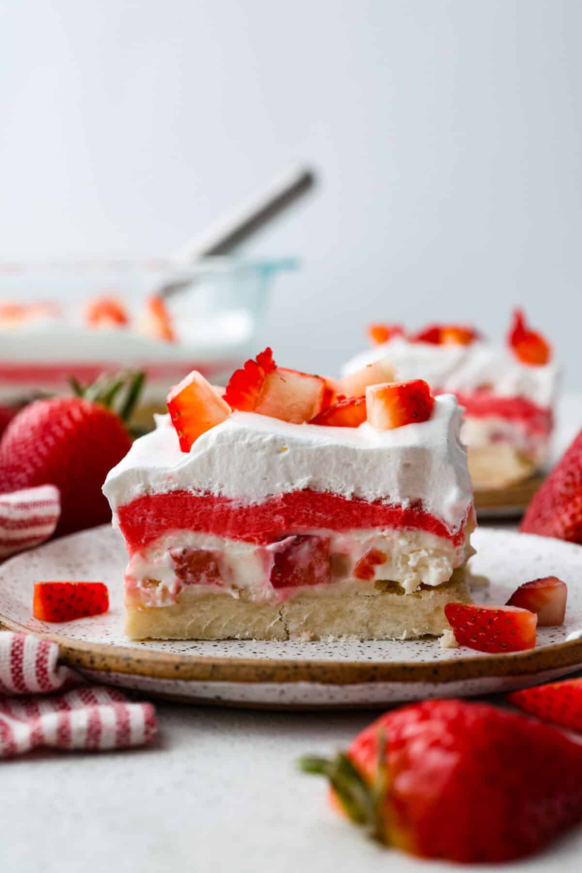 My Strawberry Delight is the ultimate summer showstopper! Buttery crust, juicy strawberries, sweet jello, and fluffy toppingโone bite and everyoneโs hooked. Side shot of strawberry delight on a plate.