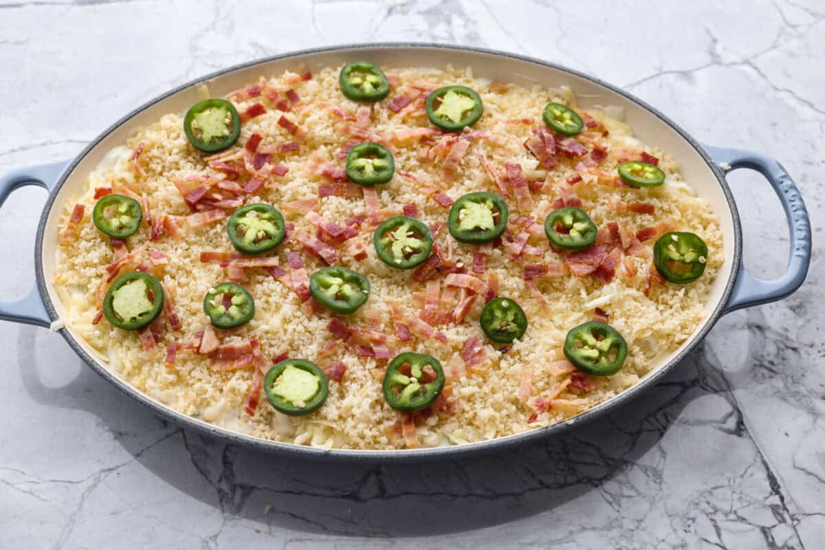 You guys, this Jalapeño Popper Mac and Cheese is downright sinful in the best way. Creamy, cheesy, spicy, and loaded with comfort food goodness! It’s easy to put together, and trust me, it’s so worth it! Mac and cheese ingredients topped with the crunchy topping ingredients and extra bacon and sliced jalapeños.