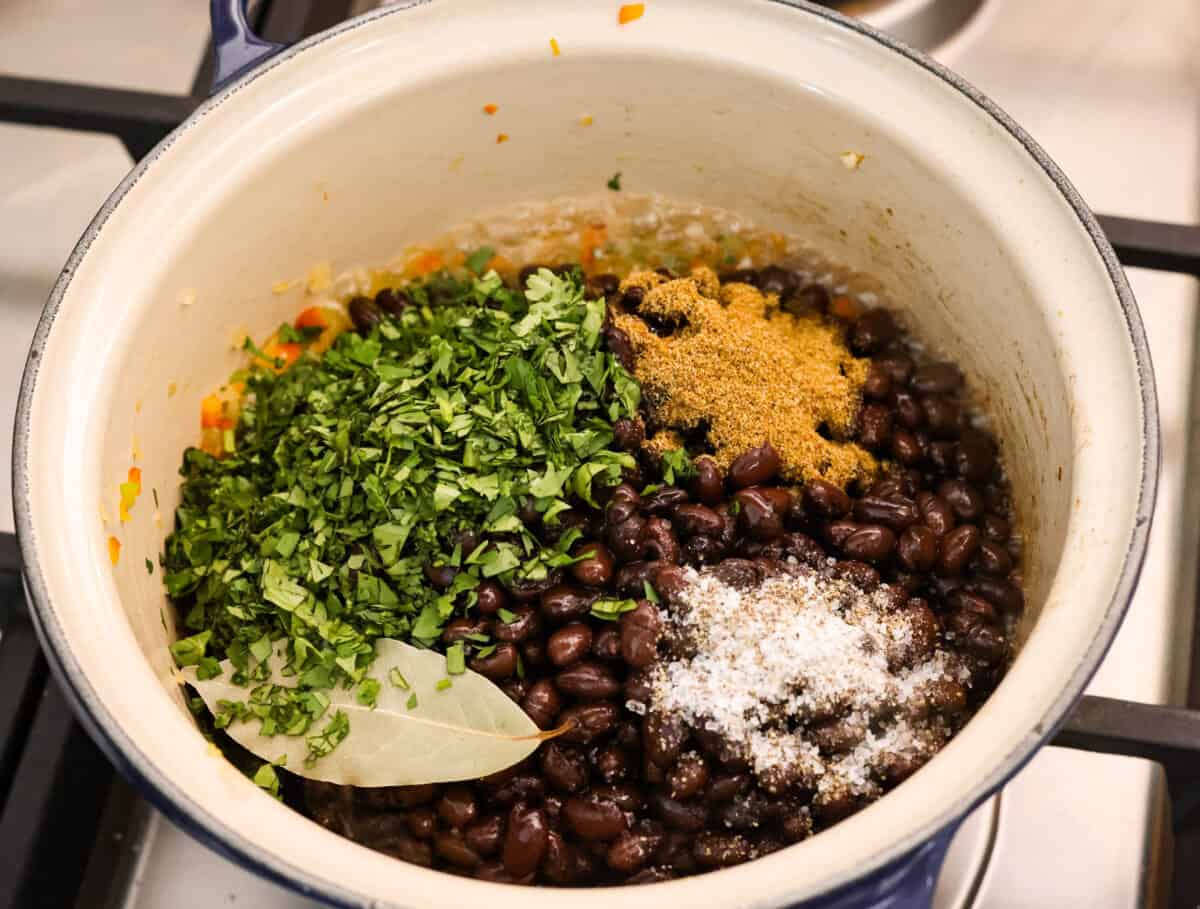 For these Cuban Black Beans, I used canned black beans to save time on soaking and cooking, so you can enjoy that rich, homemade flavor in a fraction of the time! Black beans, cilantro and other seasonings added to the onion mixture in the pot.