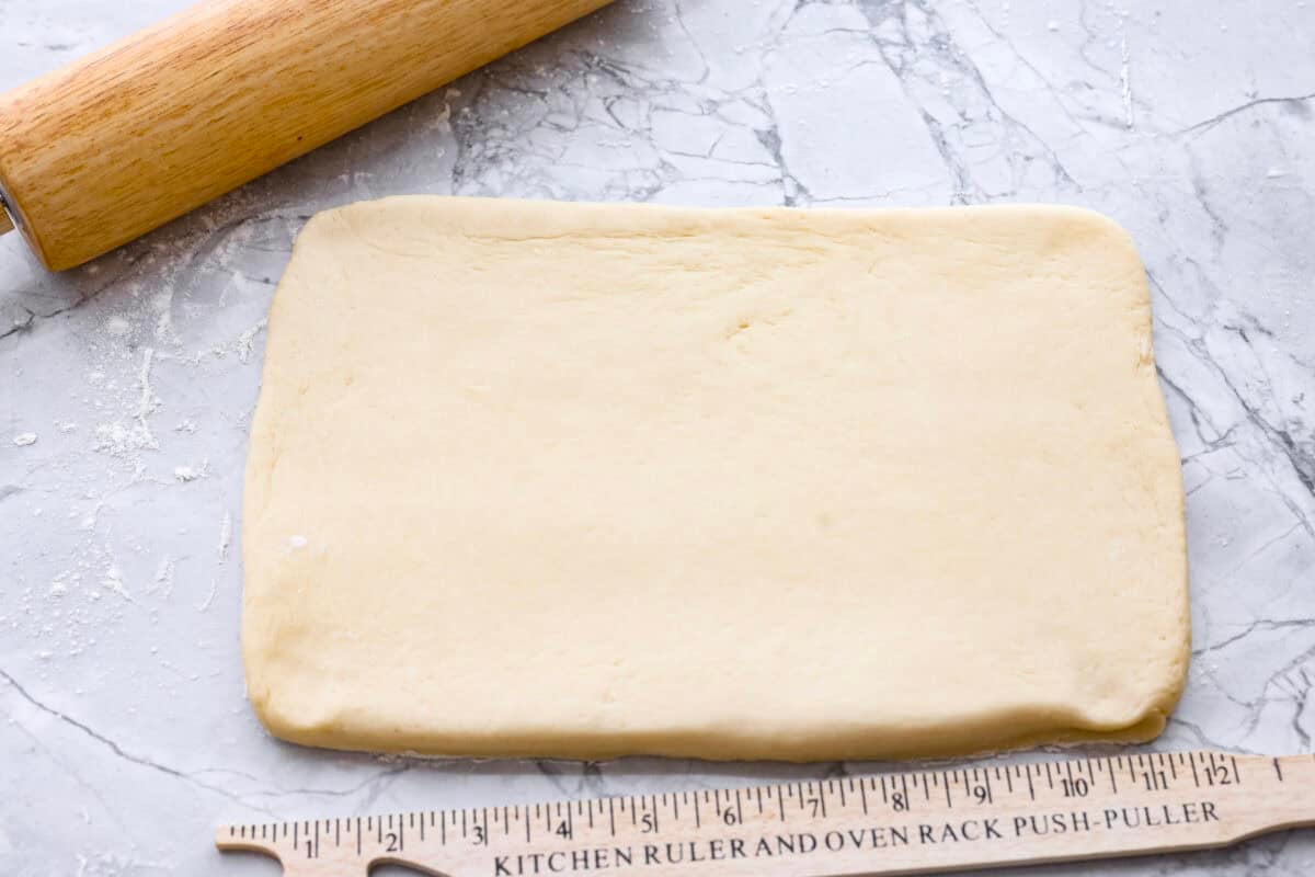 I am obsessed with Texas Roadhouse rollsโlike, zero self-control as soon as they hit the table. So, of course, I had to recreate them at home! These copycat Texas Roadhouse rolls are soft, fluffy, slightly sweet, and melt-in-your-mouth good. Dough rolled out on to a floured countertop into a rectangle.