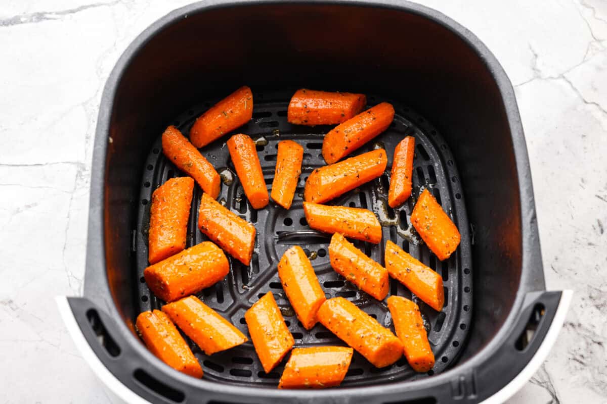 If there’s one side dish that never sticks around for long at my house, it’s these air fryer carrots! They’re crisp on the outside, tender inside, and seasoned to bring out all their natural sweetness—even the picky eaters love them! Seasoned carrots in an air fryer basket.