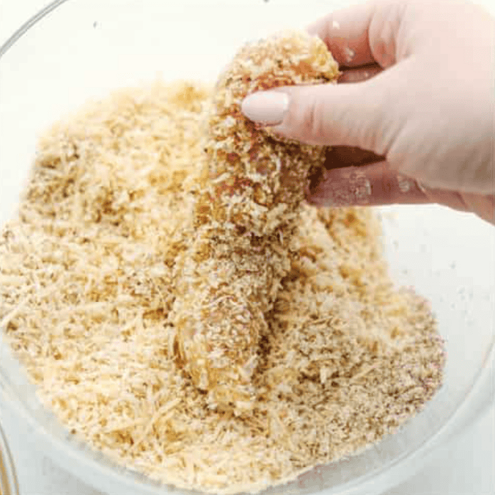 These air fryer chicken tenders are a lifesaver on crazy weeknights. Crispy, cheesy, and full of flavorโplus they cook up fast and my kidsย actuallyย ask for seconds. Total win! Chicken tender being coated with breadcrumbs.