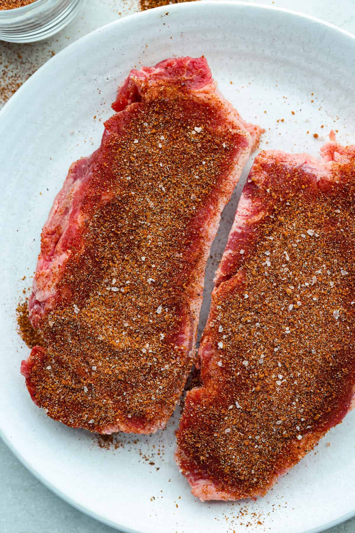My homemade BBQ seasoning brings bold, smoky flavor to just about anything! Itโs the perfect blend of sweet, savory, and just a little kick, ready to shake onto chicken, veggies, ribs, and more. Two steaks seasoned with homemade bbq seasoning.