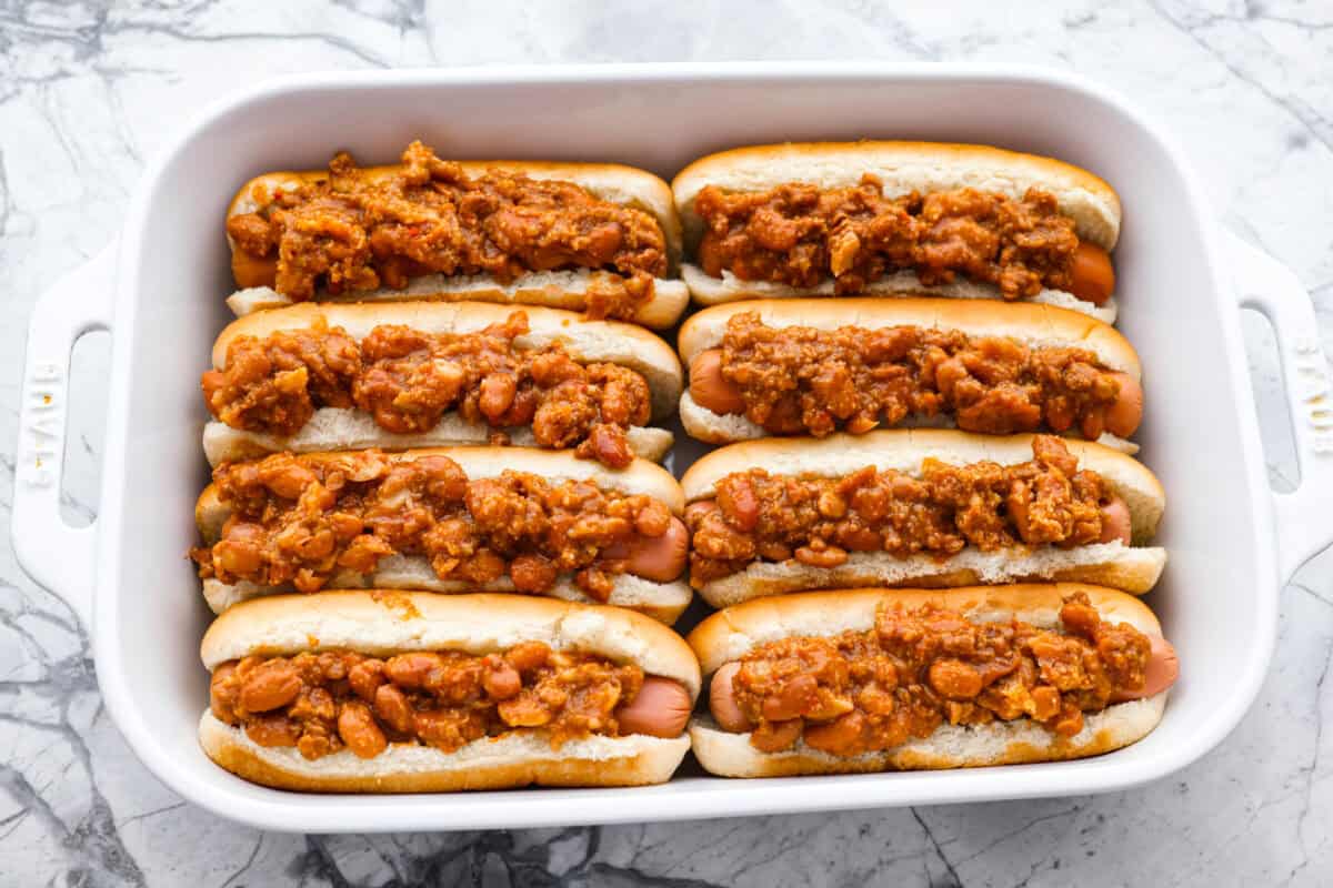 These Baked Chili Cheese Dogs are dangerously good. We’re talking soft buns, hearty chili, and ooey gooey cheese. They’re quick, messy (in the best way), and totally delicious! Chili on top of the hot dogs.
