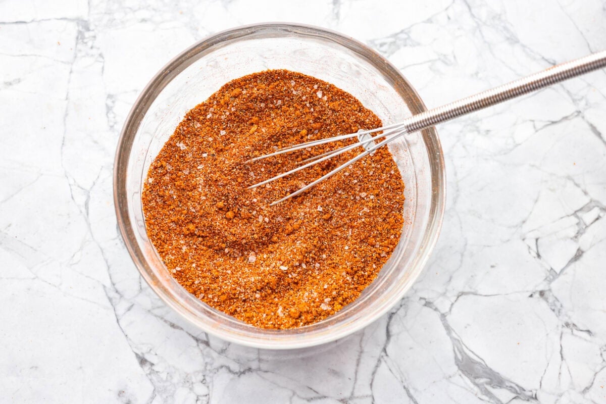 My homemade BBQ seasoning brings bold, smoky flavor to just about anything! Itโs the perfect blend of sweet, savory, and just a little kick, ready to shake onto chicken, veggies, ribs, and more. A bowl with all of the ingredients whisked together.