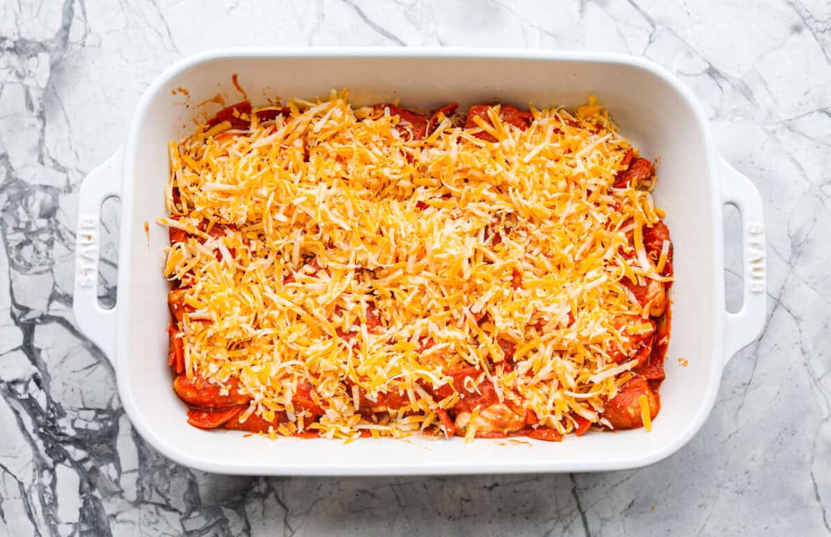 Bubble Pizza is what you make when you want something cozy, cheesy, and easy. Think pizza meets pull-apart bread with zero rolling, stretching, or takeout guilt. Cheese sprinkled on top of the bubble pizza ingredients.