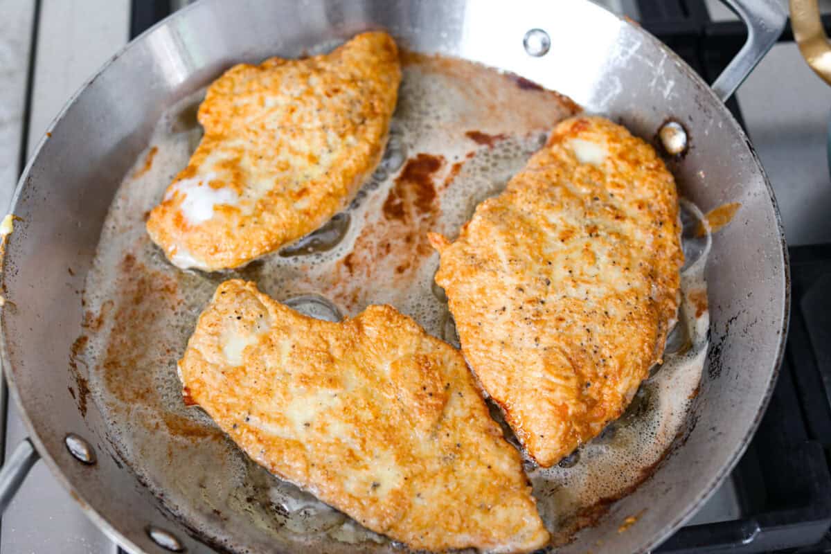 If youโve never had Chicken Francese, youโre in for a treat! Lightly breaded chicken, pan-fried to golden perfection, then bathed in a bright, buttery lemon sauce thatโs totally irresistible. Breasts cooking in a skillet with vegetable oil.