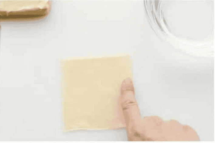 If you guys are as obsessed with cream cheese wontons as I am, you are going to love this easy-to-follow recipe! These crispy, creamy, wontons are totally doable! Someone putting water on the edges of the wonton wrapper.