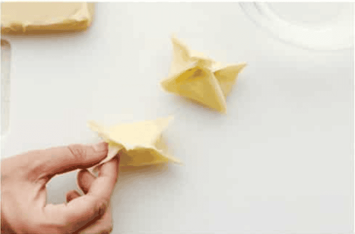 If you guys are as obsessed with cream cheese wontons as I am, you are going to love this easy-to-follow recipe! These crispy, creamy, wontons are totally doable! Someone wrapping up and sealing the wonton.