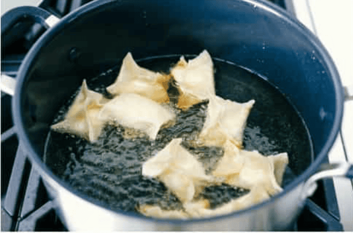 If you guys are as obsessed with cream cheese wontons as I am, you are going to love this easy-to-follow recipe! These crispy, creamy, wontons are totally doable! Wontons frying in oil.